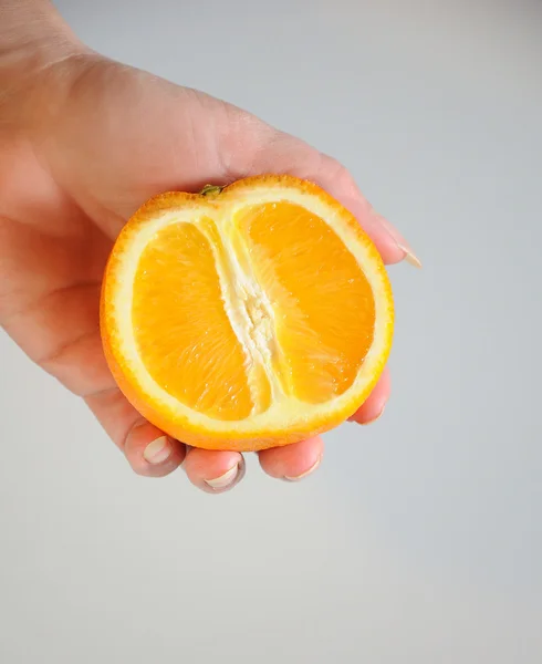 Half of orange in hand — Stock Photo, Image