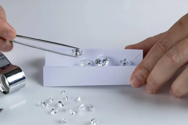 Close-up van diamantexperts hand op werkplaats voor de beoordeling van geslepen diamanten. — Stockfoto