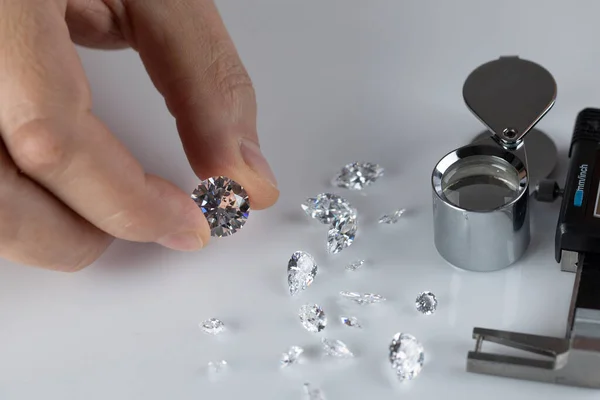 Gyémánt szakértők közelsége a munkahelyen, drágaköveket értékelve csiszolt gyémántokat. — Stock Fotó
