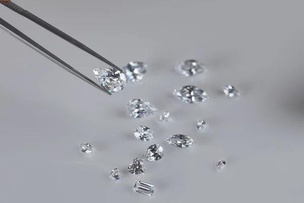 Primer plano de expertos en diamantes mano en el lugar de trabajo la evaluación de piedras preciosas diamantes pulidos. — Foto de Stock