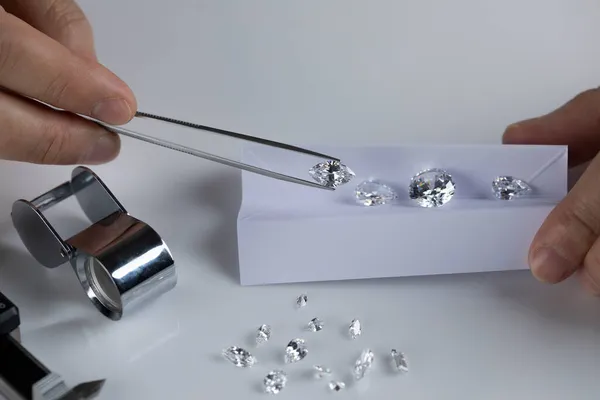 Close-up van diamantexperts hand op werkplaats voor de beoordeling van geslepen diamanten. — Stockfoto