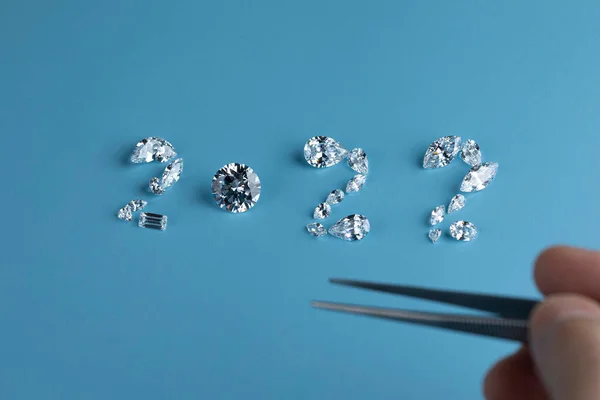 Διαδικασία καθορισμού του αριθμού 2022 από διαμάντια διαφόρων μεγεθών και σχημάτων με τη χρήση εργαλείων στο χώρο εργασίας του εμπόρου διαμαντιών. Έννοια της επιχείρησης διαμαντιών 2022. — Φωτογραφία Αρχείου