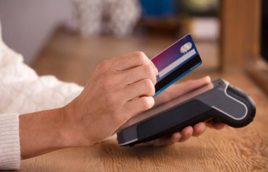 Faturayla işlem ödemesi yapan genç bir kadın ya da POS nakit terminalinin faturasını bir dükkanda, finansal konseptte kesiyor. Eline odaklan.