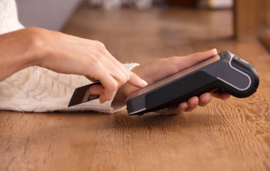 Faturayla ödeme yapan genç bir kadın ya da POS nakit terminalinin faturasını bir dükkanda, finansal dolandırıcılıkta kesiyor. Parmağına odaklan..