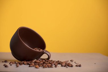 Kahverengi kahve ya da çikolata, sarı arka planda raffia çuvalları.