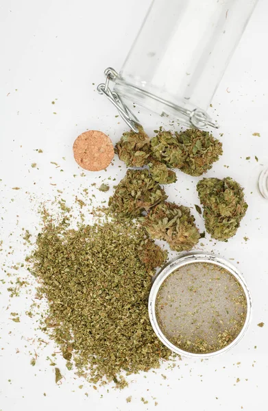 Ovanifrån Marijuana Knoppar Med Kvarn Tillbehör Glasflaskor Och Vit Bakgrund — Stockfoto