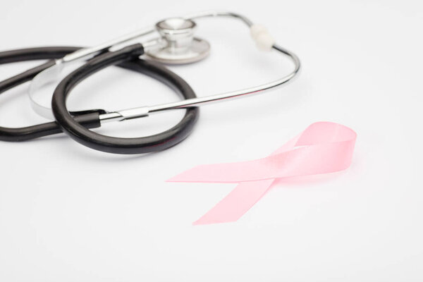 pink cancer ribbon with, stethoscope, white background ,international symbol of breast cancer awareness and moral support for women. Isolated background,