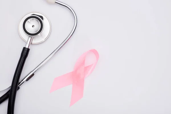 pink cancer ribbon with, stethoscope, white background ,international symbol of breast cancer awareness and moral support for women. Isolated background,