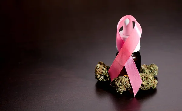 Różowa Wstążka Symbol Walki Raka Butelką Oleju Pąki Marihuany Brązowym — Zdjęcie stockowe