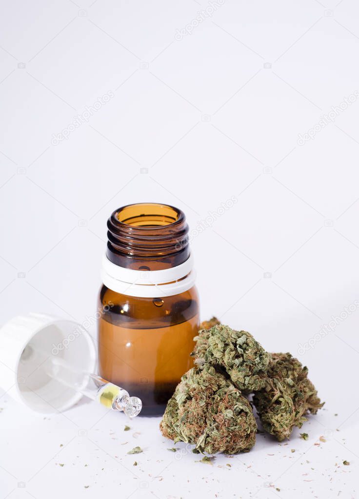 set of marijuana buds, with dispenser bottle, white background.