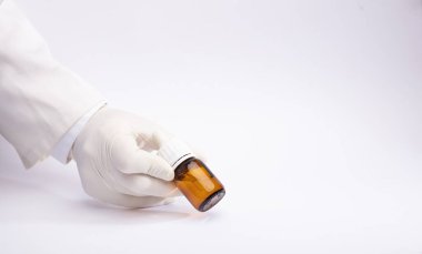 Teslimat kutusunda marihuana yağı eldivenli ellerde, beyaz arka planda.