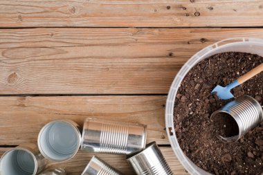 Evde yaratıcı geri dönüşüm, alüminyum kutular ve üzerinde toprak olan geri dönüşümlü plastik kaplar. 