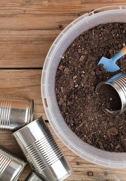 Bahçe için geri dönüşümlü tencereler, çalışma masasında bahçe aletleri