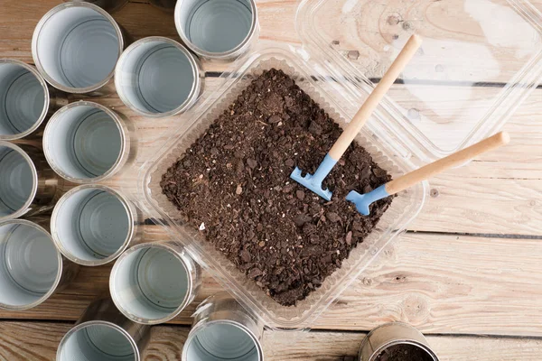 Bahçe için geri dönüşümlü tencereler, çalışma masasında bahçe aletleri