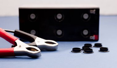 pil bakım konsepti, pil pozitif ve negatif kutuplu kırmızı ve siyah bağlantı pimleri, mavi arkaplan