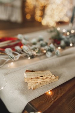 Kutsal Palo Santo ağacının sopaları Noel masasının üzerinde. Aromaterapi. Meditasyon çubukları. tatil atmosferi, dikey, seçici odaklanma