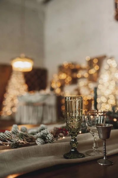 ベージュと木製の色でシックなクリスマステーブルの設定 金のカトラリー付きガラス キャンドル ボケの背景とクリスマスのインテリアに対する綿やガーランド 選択的な焦点 ストックフォト