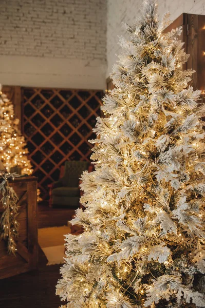 ワインキャビネットの背景に金の装飾やガーランドと背の高いクリスマスツリー 選択的焦点 ストック画像