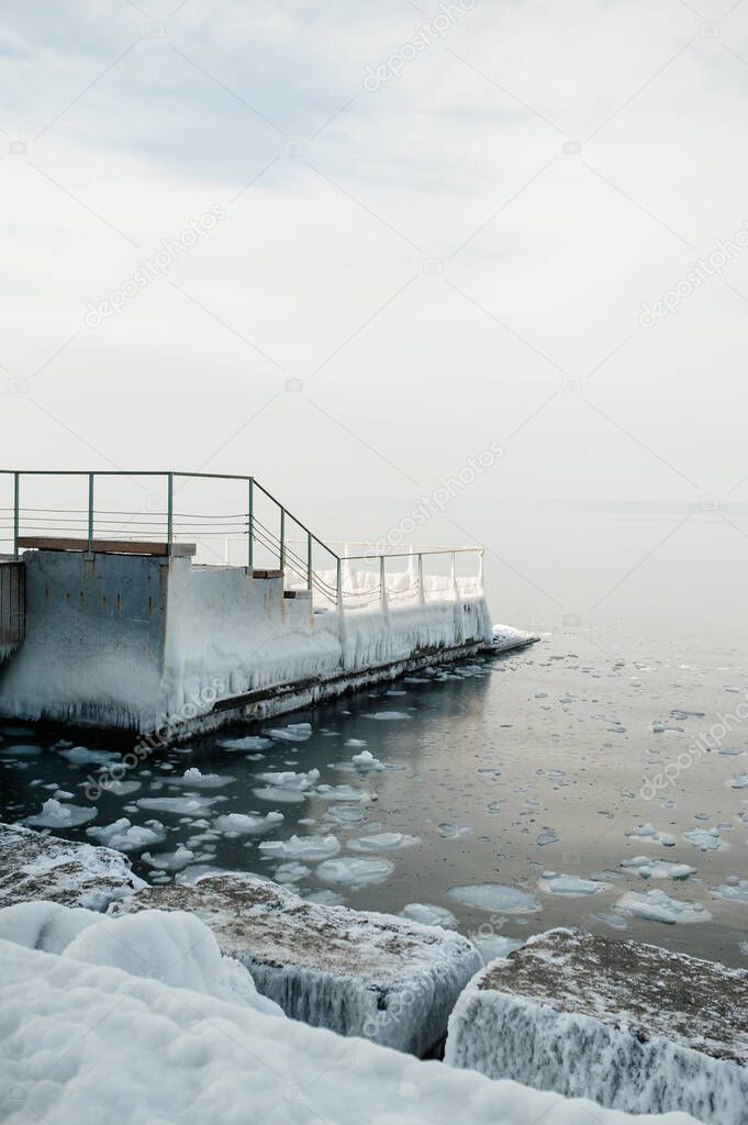 icy pier and the sea in ice floes. winter landscape. selective focus