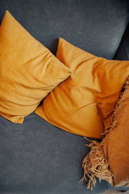 Gri bir kanepede parlak sarı yastıklar. İç dekorun görüntüsü. dikey, seçici odak