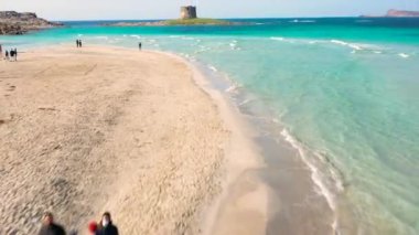 Akdeniz 'in Stintino, La Pelosa sahilindeki bir adada Nuraghe' nin hava 4K videosu. Sardunya.