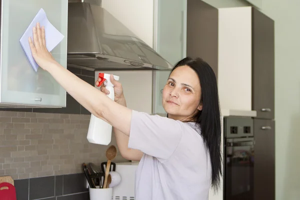 Donna sorridente che pulisce i mobili — Foto Stock