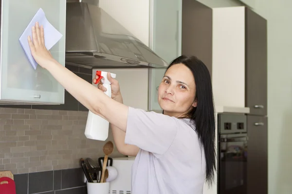 Mulher sorridente limpando a mobília — Fotografia de Stock