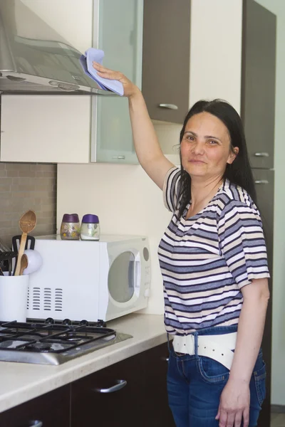 Mulher adulta limpando o mobiliário — Fotografia de Stock