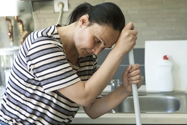 Müde Frau ruht auf Wischmopp — Stockfoto