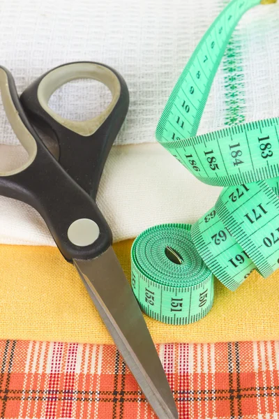 Tape-line, scissors and fabric samples close up — Stock Photo, Image