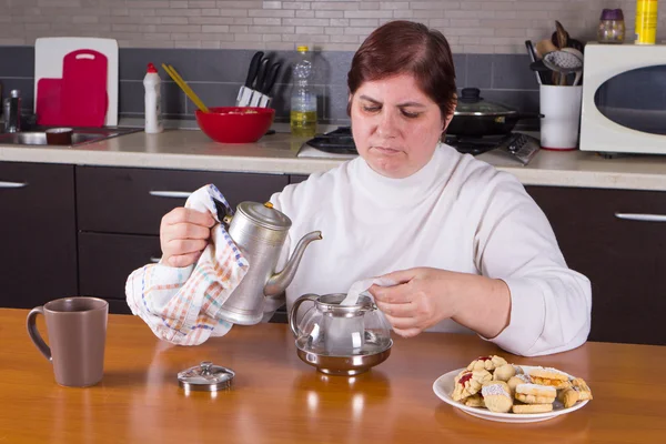 Mujer de mediana edad haciendo té en la cocina — Foto de Stock