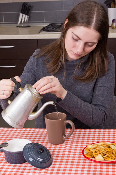Jong meisje het maken van thee in kitchen — Stockfoto