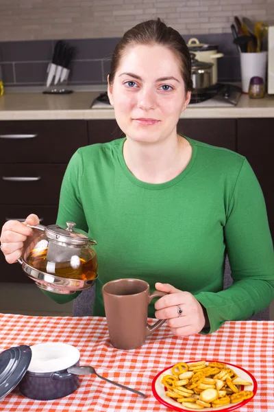 Young girl drinking tea at kitchen — Stock Photo, Image