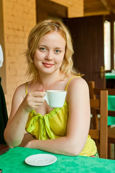 Chica joven bebiendo capuchino — Foto de Stock