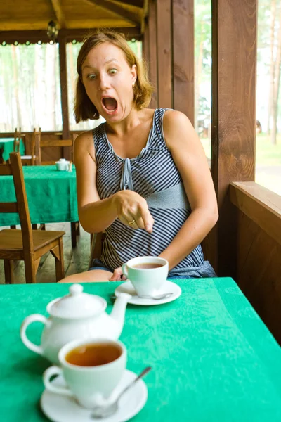 Shocked girl sees something in cup of tea — Stock Photo, Image