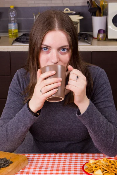 年轻的女孩在厨房里喝着茶 — 图库照片