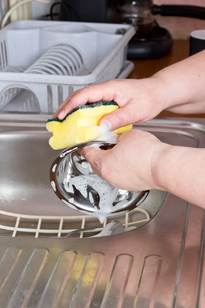 Housewife washing dishes in sink — Stock Photo, Image