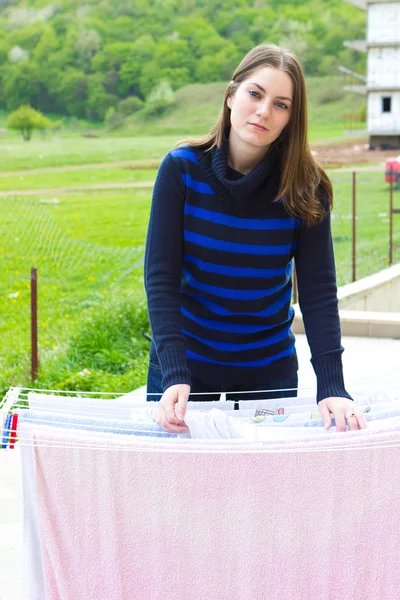 Junges Mädchen hängt Tücher an Wäscheleine — Stockfoto