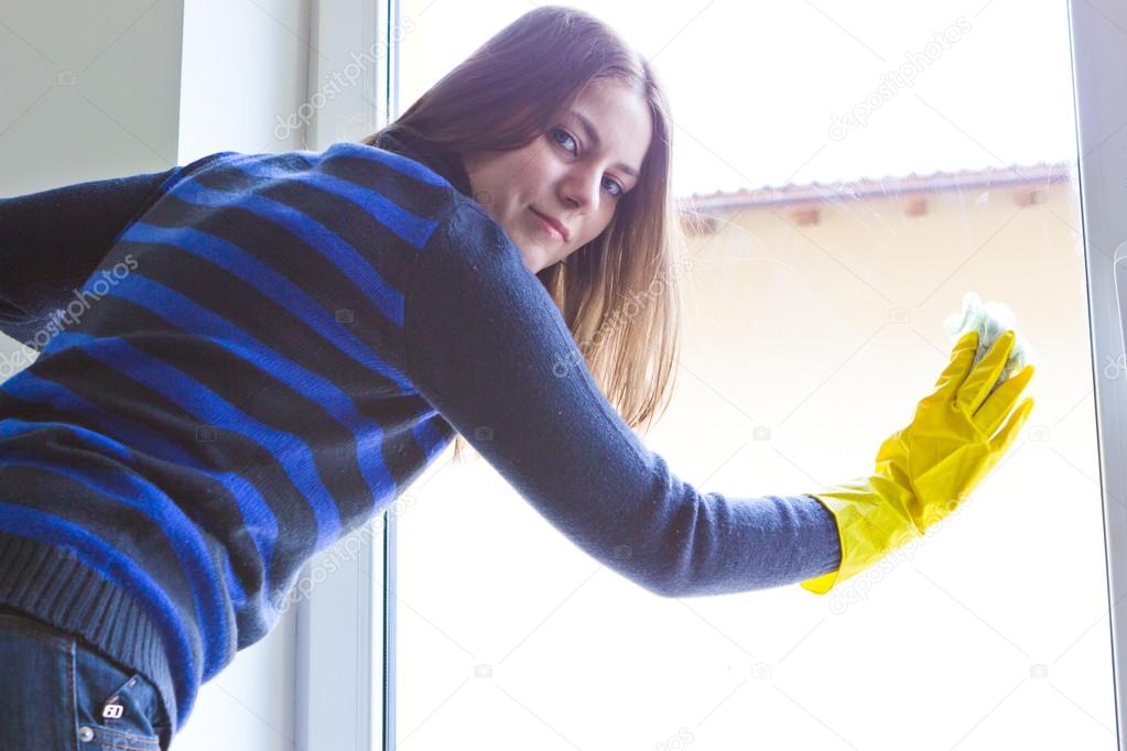 Young girl washing windows