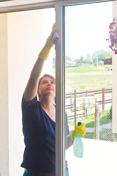 Jovem menina lavando janelas — Fotografia de Stock