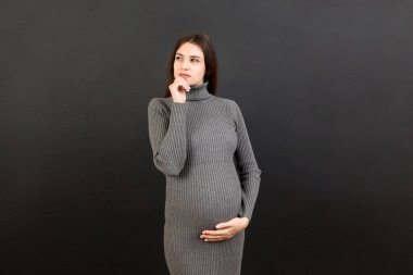 Düşünceli hamile kadın renkli arka planda bebek için isim seçiyor. Hayal Eden ve Mutlu Hamile Kadın Düşünen Annelik Hayatı. Boşluğu Kopyala.
