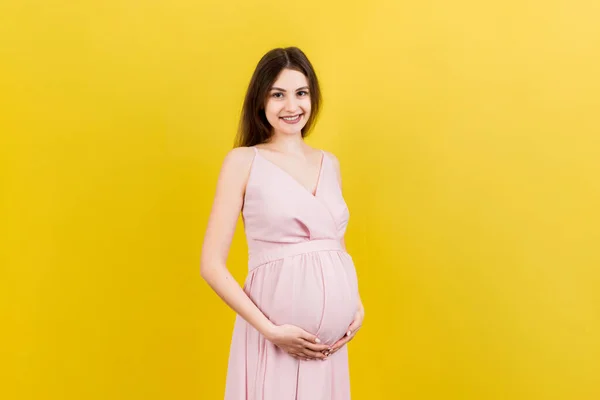 Счастливая Беременная Женщина Трогает Живот Цветном Фоне Будущая Мать Носит — стоковое фото