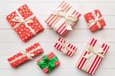 Masada renkli kağıtlarla süslenmiş bir sürü Noel hediyesi kutusu var. Birçok hediye var..