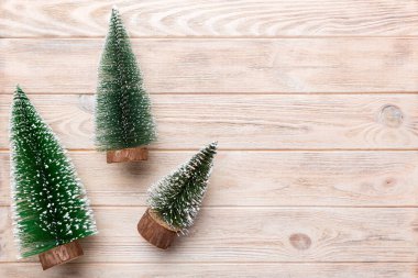 Renkli arka planda noel ağaçları olan düz kompozisyon. Kopyalama alanı olan üst görünüm.