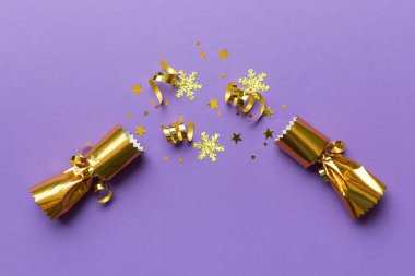 Renkli arka planda parlak konfetileri olan Noel krakerleri, üst görünüm, boşluk kopyala.
