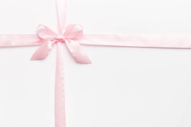 Mor kurdelenin üst görüntüsü yuvarlandı ve pembe fiyonk renkli arka planda izole edildi. Kopyalama alanı olan düz.