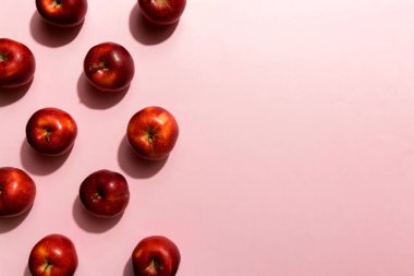 Renkli arka planda bir sürü kırmızı elma, üst manzara. Görüş üzerinde taze elma ile sonbahar deseni.