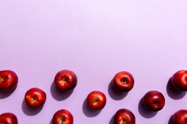 Renkli arka planda bir sürü kırmızı elma, üst manzara. Görüş üzerinde taze elma ile sonbahar deseni.