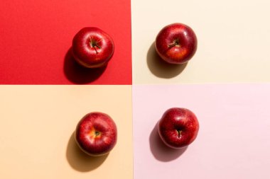 Renkli arka planda bir sürü kırmızı elma, üst manzara. Görüş üzerinde taze elma ile sonbahar deseni.