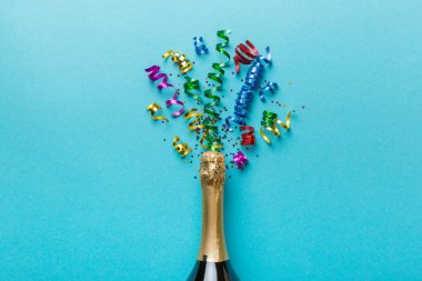 Yaratıcı düz kompozisyon, bir şişe şampanya ve renkli arka plan üzerine yazı için yer. Renkli parti flamalarıyla şampanya şişesi. tatil ya da noel konsepti.